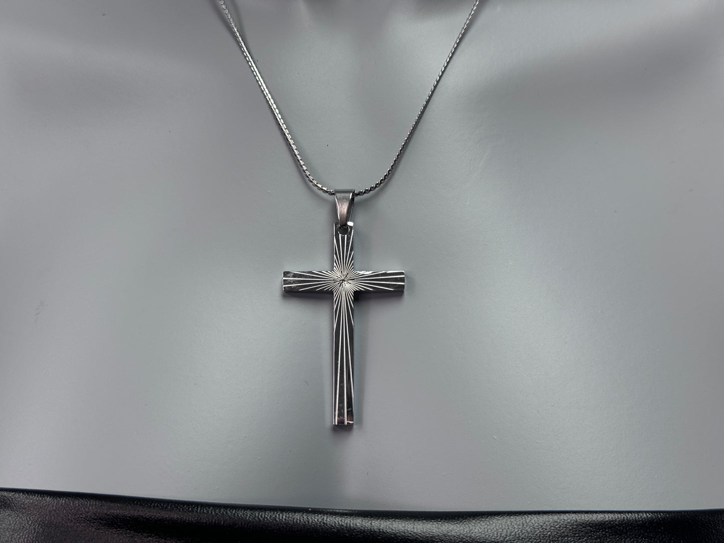 Close-up of the silver cross pendant on a 17-inch chain