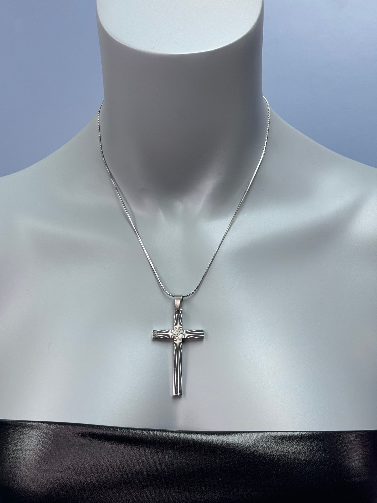 Stainless steel cross necklace displayed on a mannequin